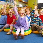 Image shows a group of toddlers looking happy